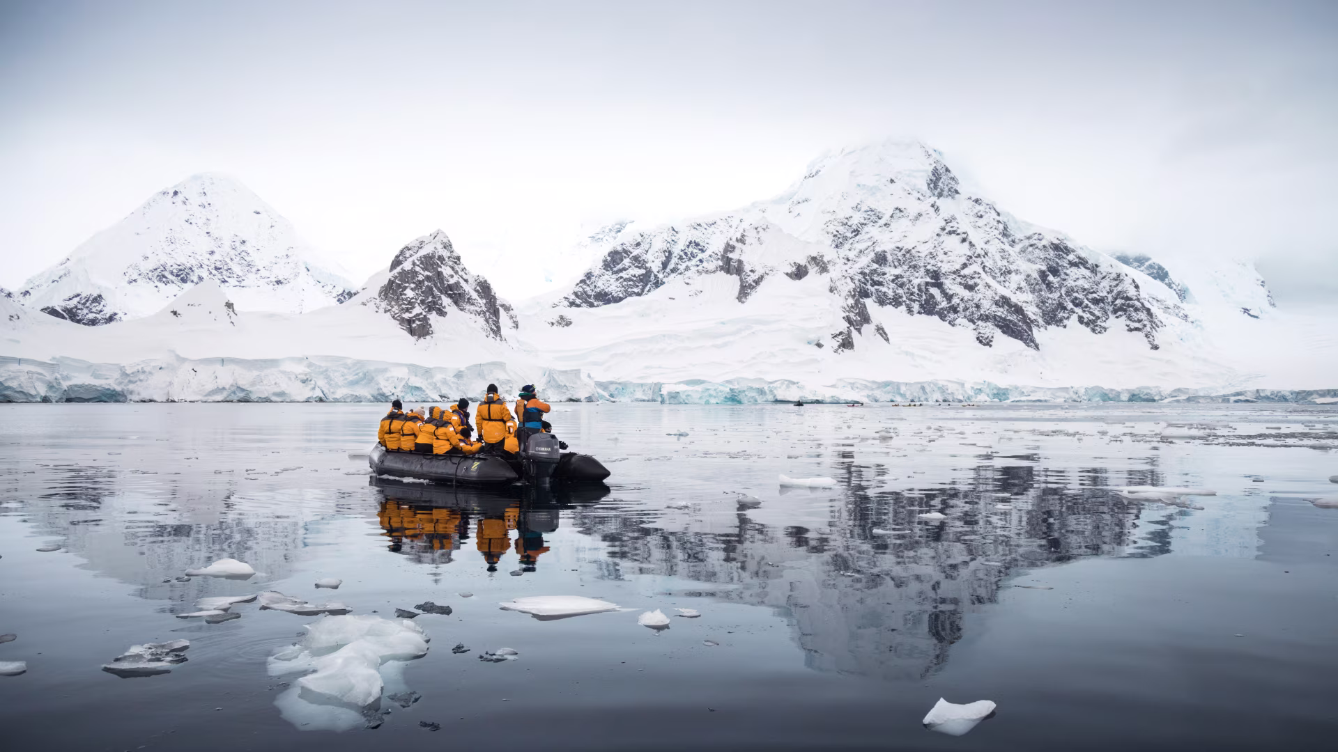 Antarctica expedition cruise guests in a Zodiac boat among icebergs